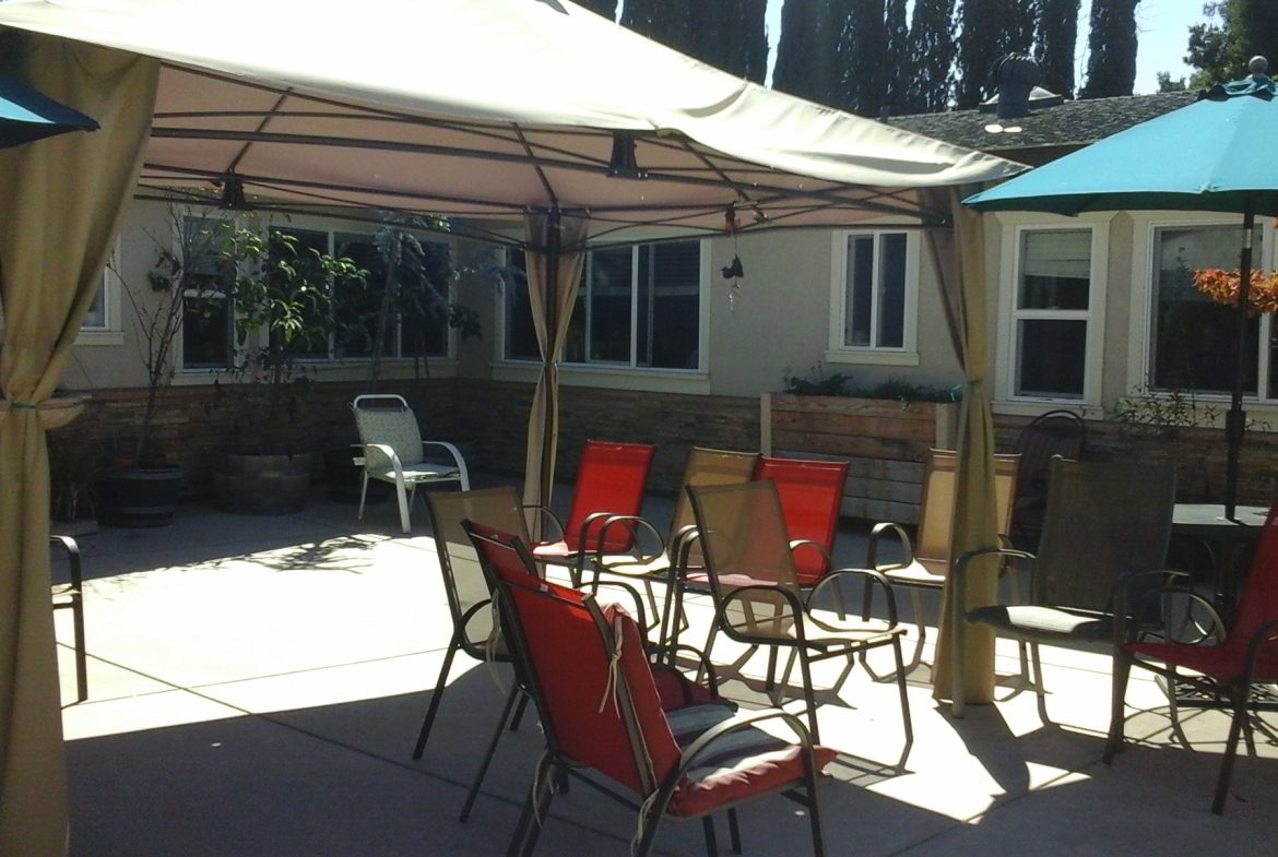 A patio with chairs and an umbrella.