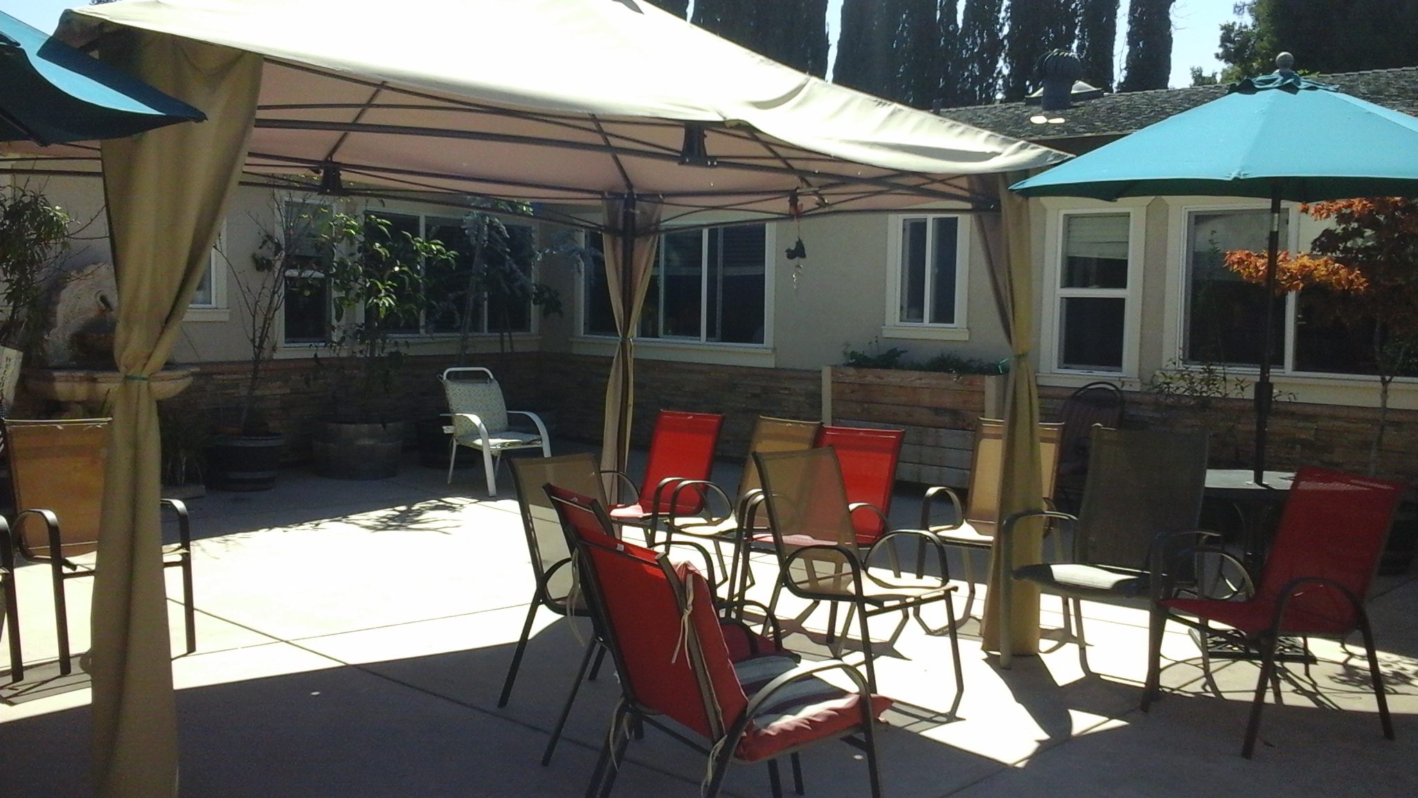 A patio with chairs and an umbrella.