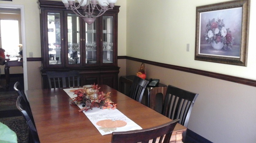 A dining room table with chairs and a china cabinet.