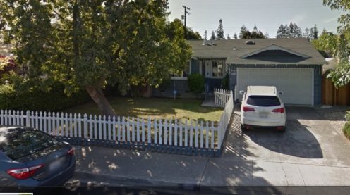 A white car parked in front of a house.