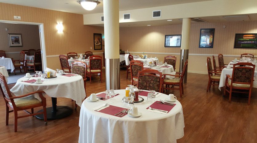 A restaurant with tables and chairs set up for breakfast.