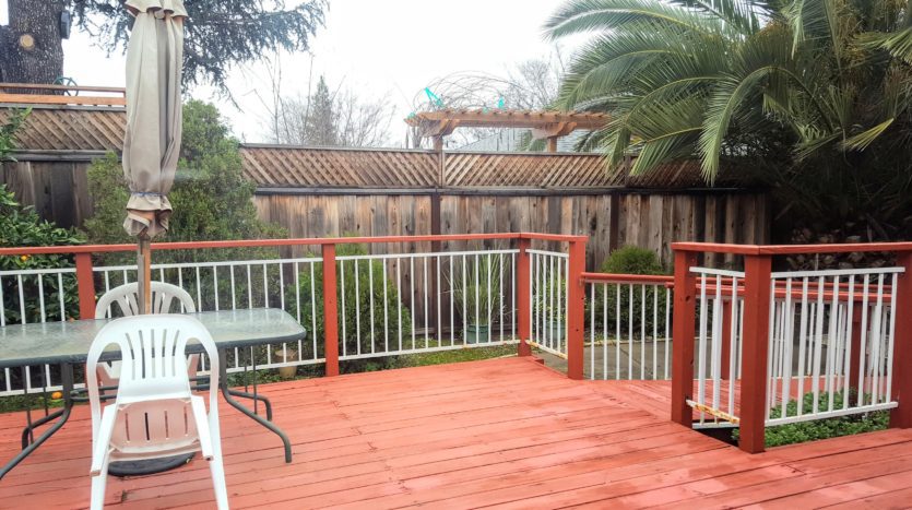 A deck with a table and chairs in the middle of it