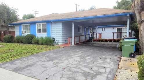 A blue house with a porch and a ramp.