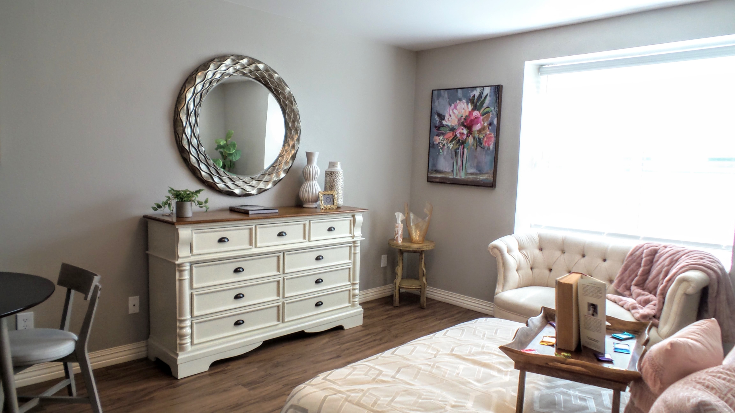 A bedroom with a dresser and chair in it