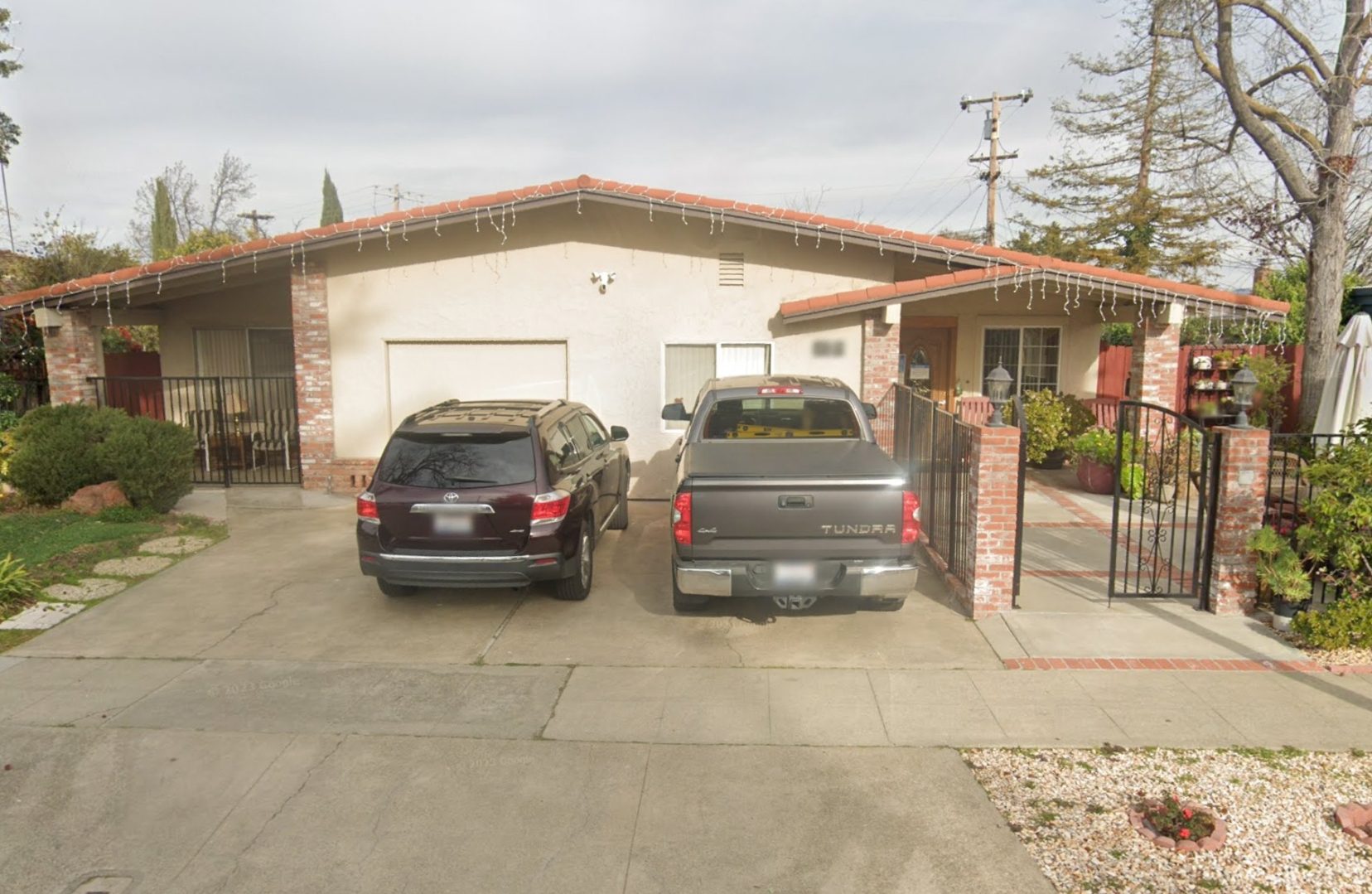 Two cars parked in a driveway next to a house.