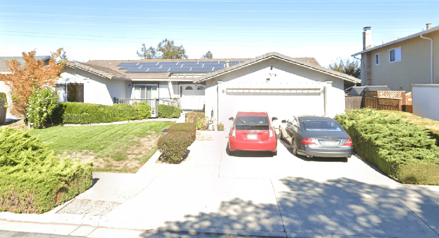 A house with two cars parked in front of it.