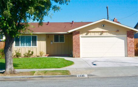 A house with a driveway and grass on the ground.