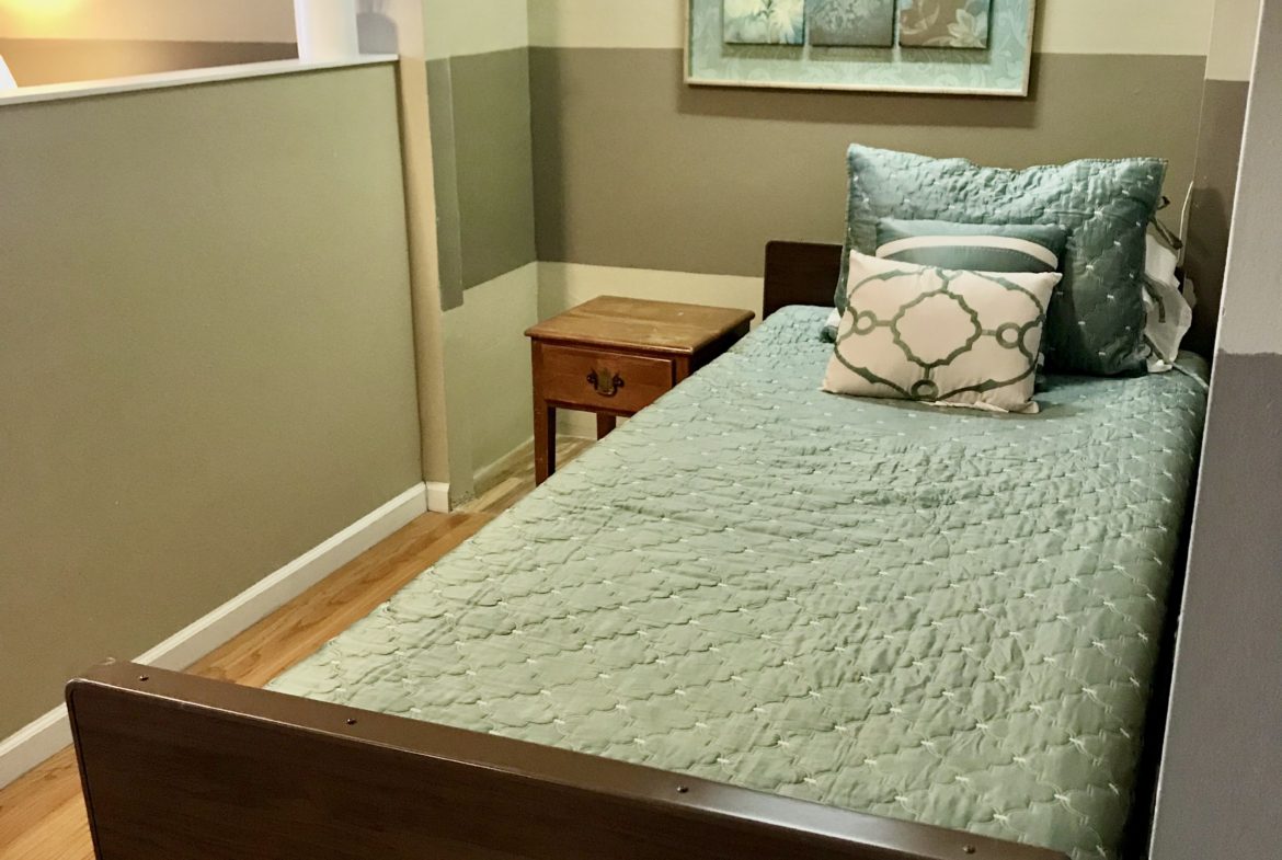 A bed room with a single bed and two night stands