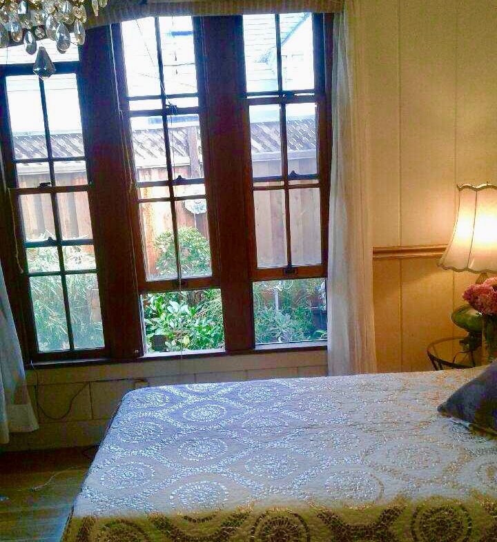 A bed room with a white bed and a window