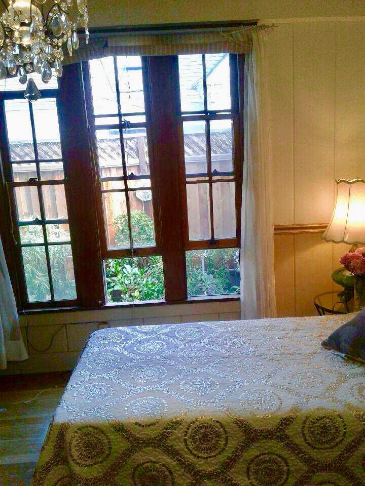 A bed room with a white bed and a window