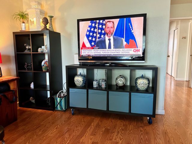 A television is on top of the tv stand.