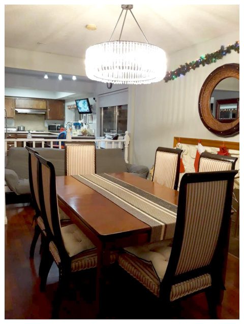 A dining room table with chairs and a mirror