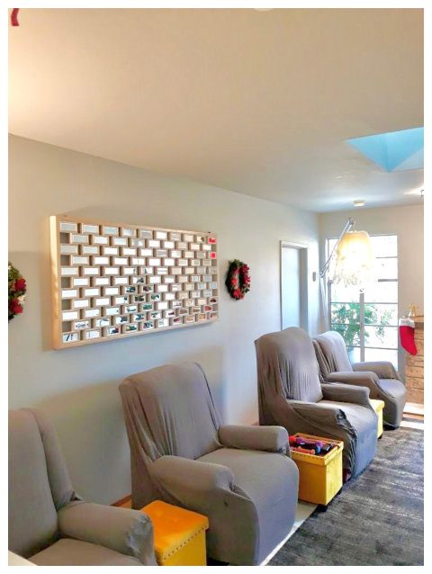 A living room with three chairs and a wall hanging.