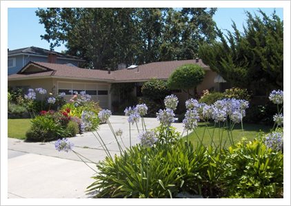 A house with flowers in the front yard.