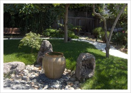 A large vase sitting in the middle of some rocks.