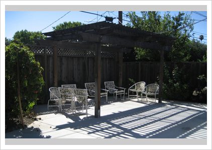 A patio with chairs and a pergola