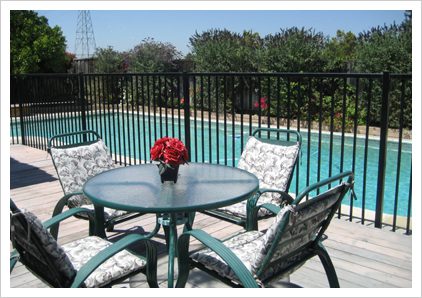 A table and chairs set up in front of the pool.