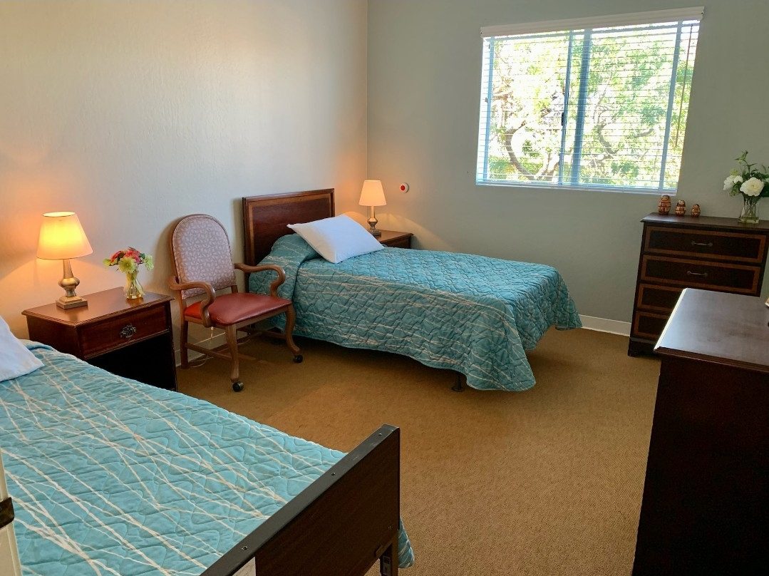 A bedroom with two beds and a desk