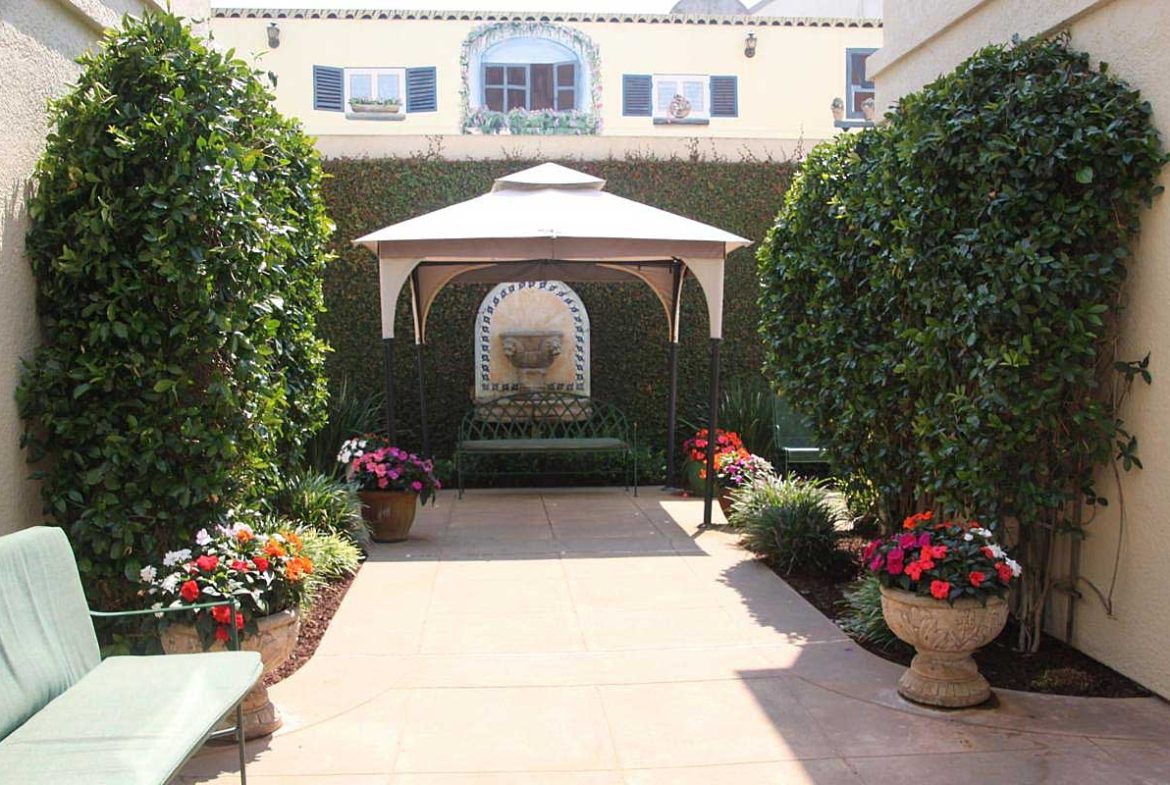 A garden with a gazebo and many flowers