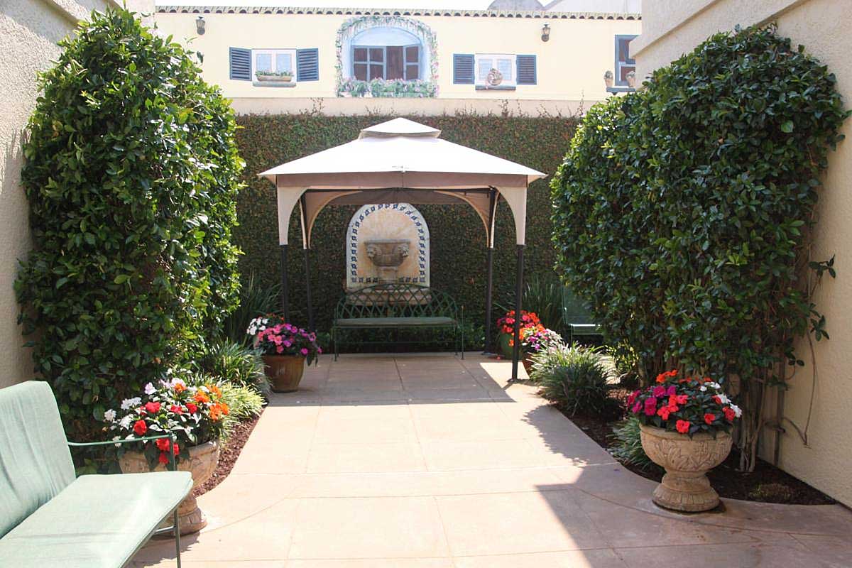 A garden with a gazebo and many flowers