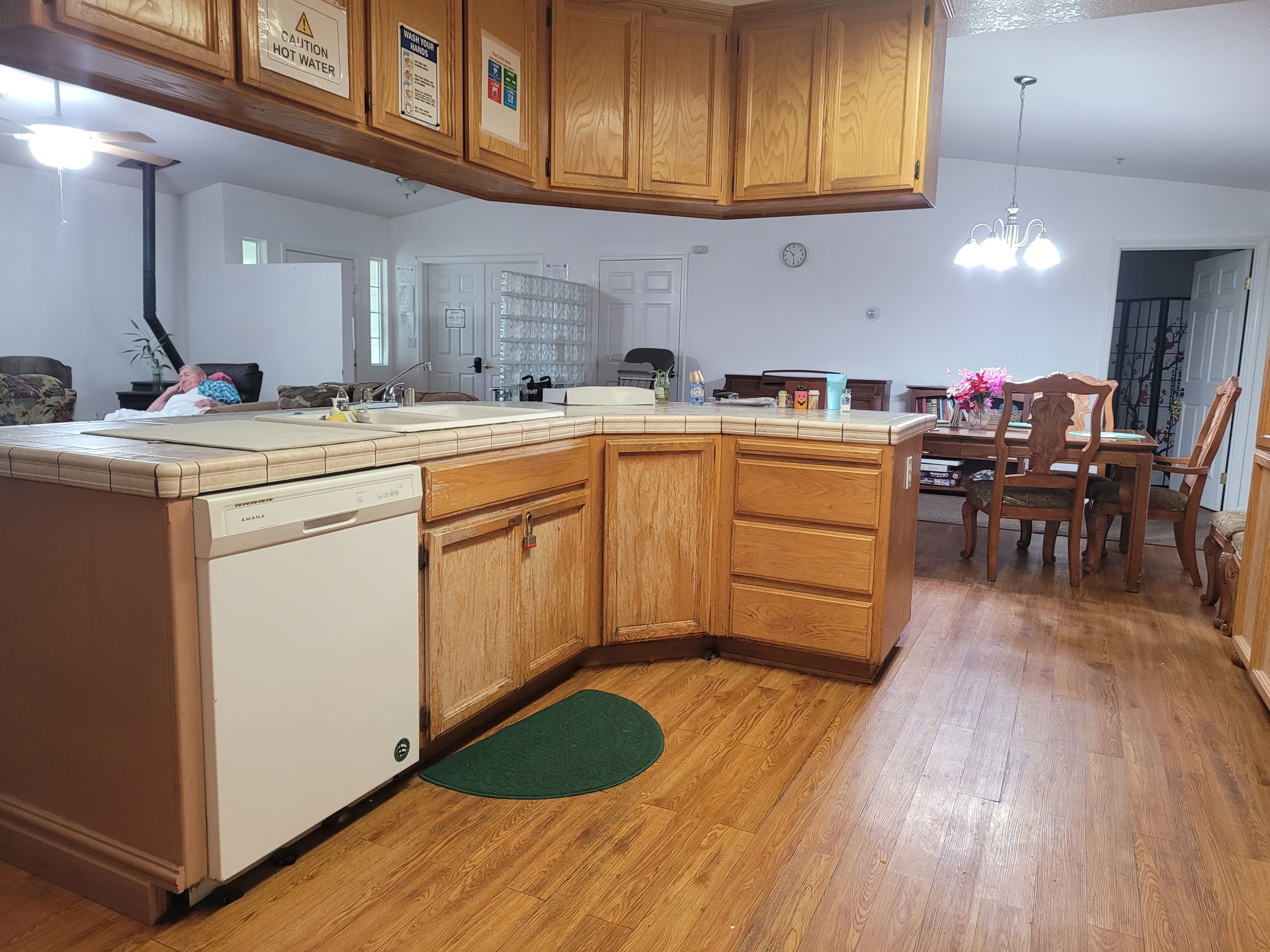 A kitchen with wooden cabinets and hard wood floors.