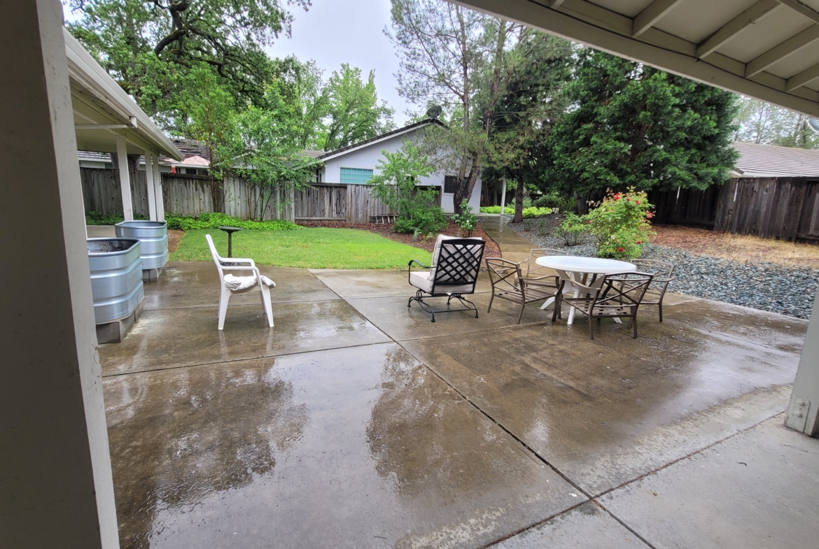 A patio with chairs and tables in the middle of it.