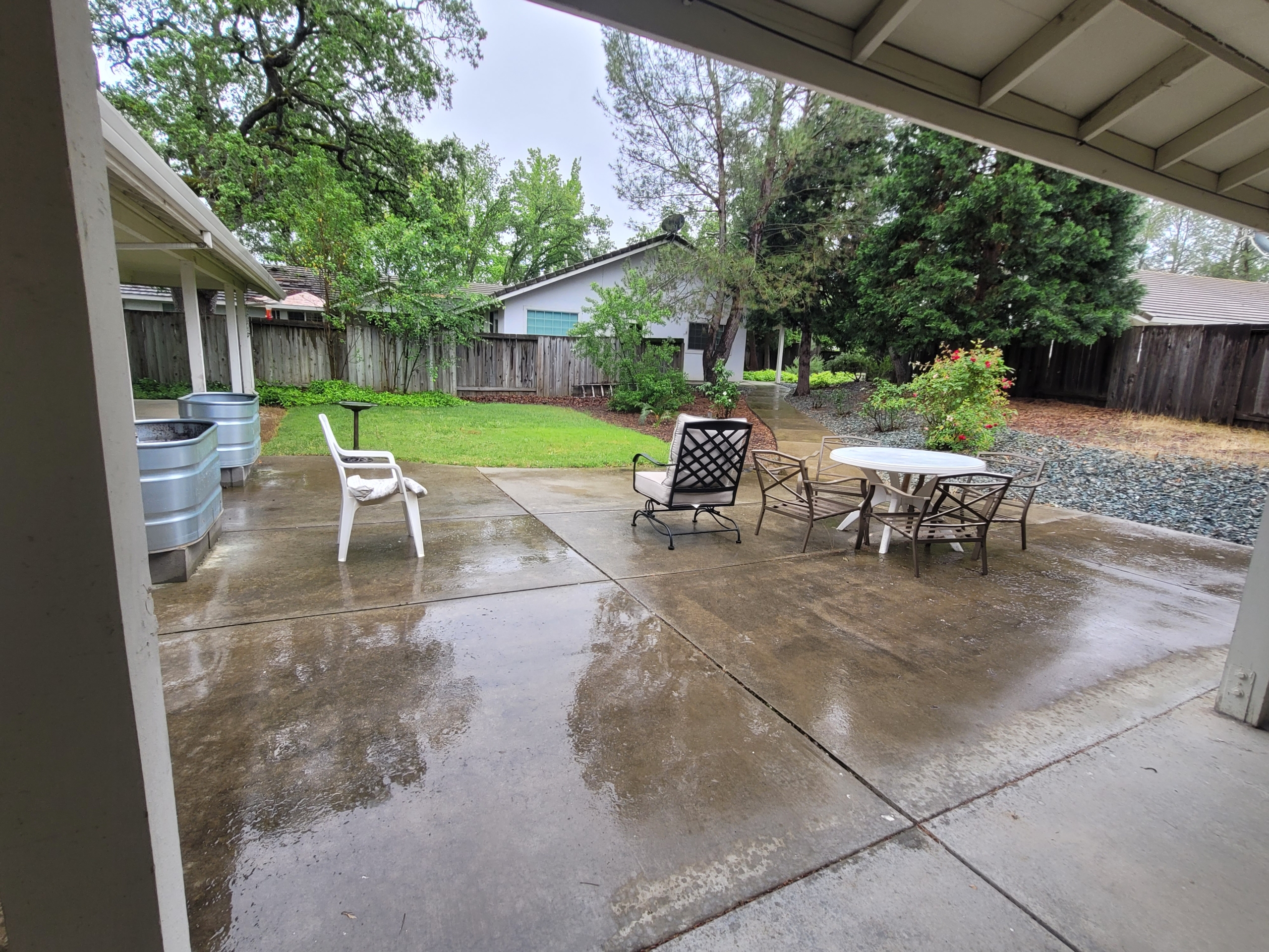 A patio with chairs and tables in the middle of it.