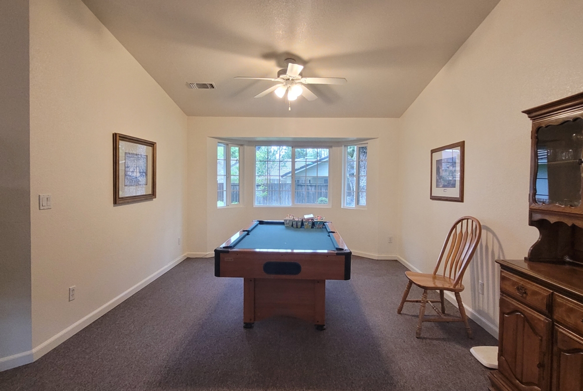 A room with a pool table and chairs in it