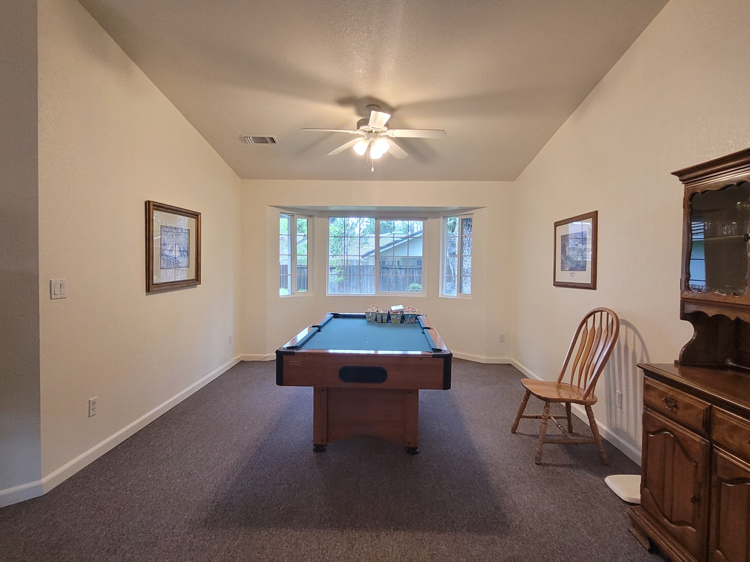 A room with a pool table and chairs in it