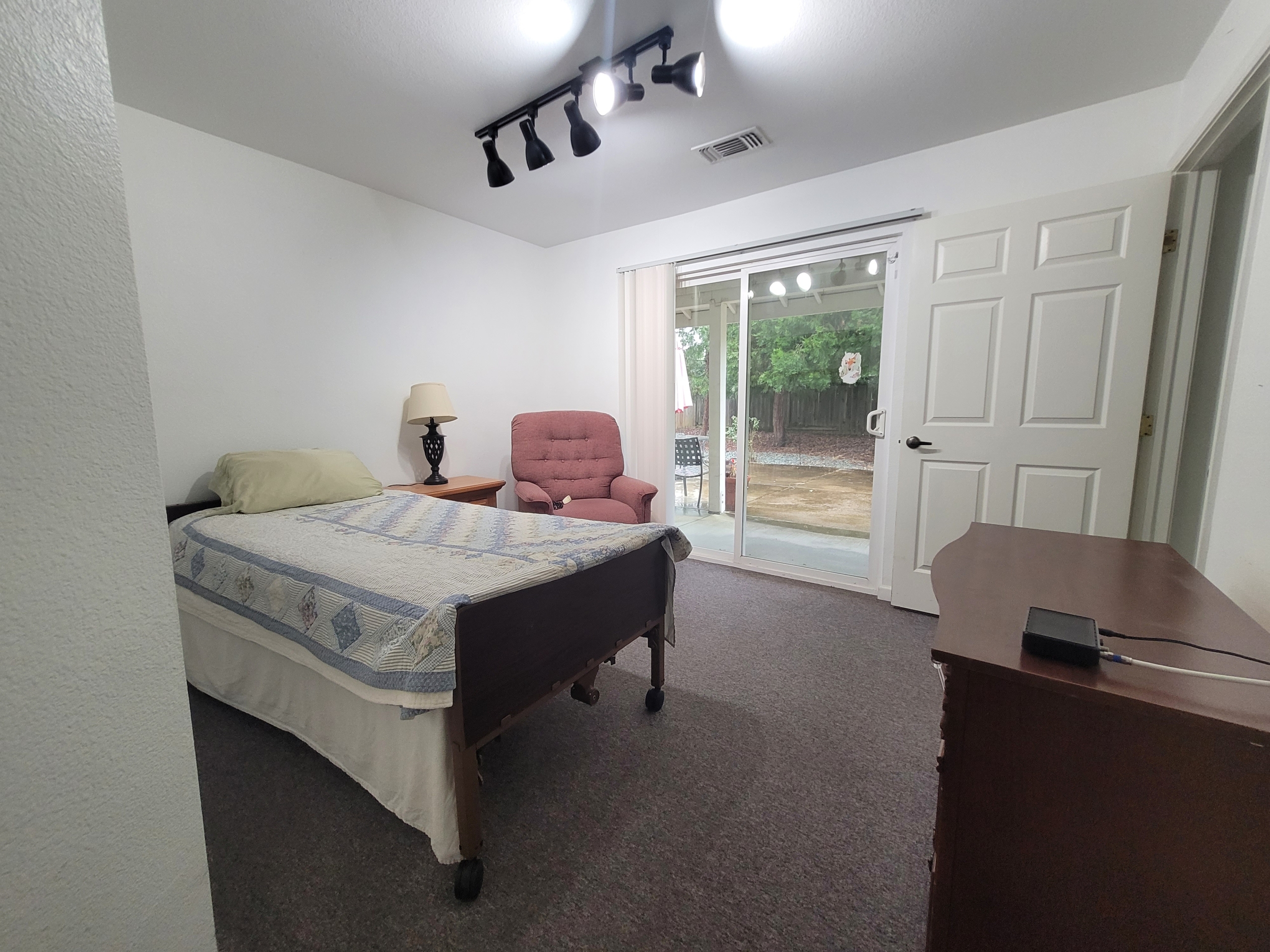 A bedroom with a bed, desk and chair.