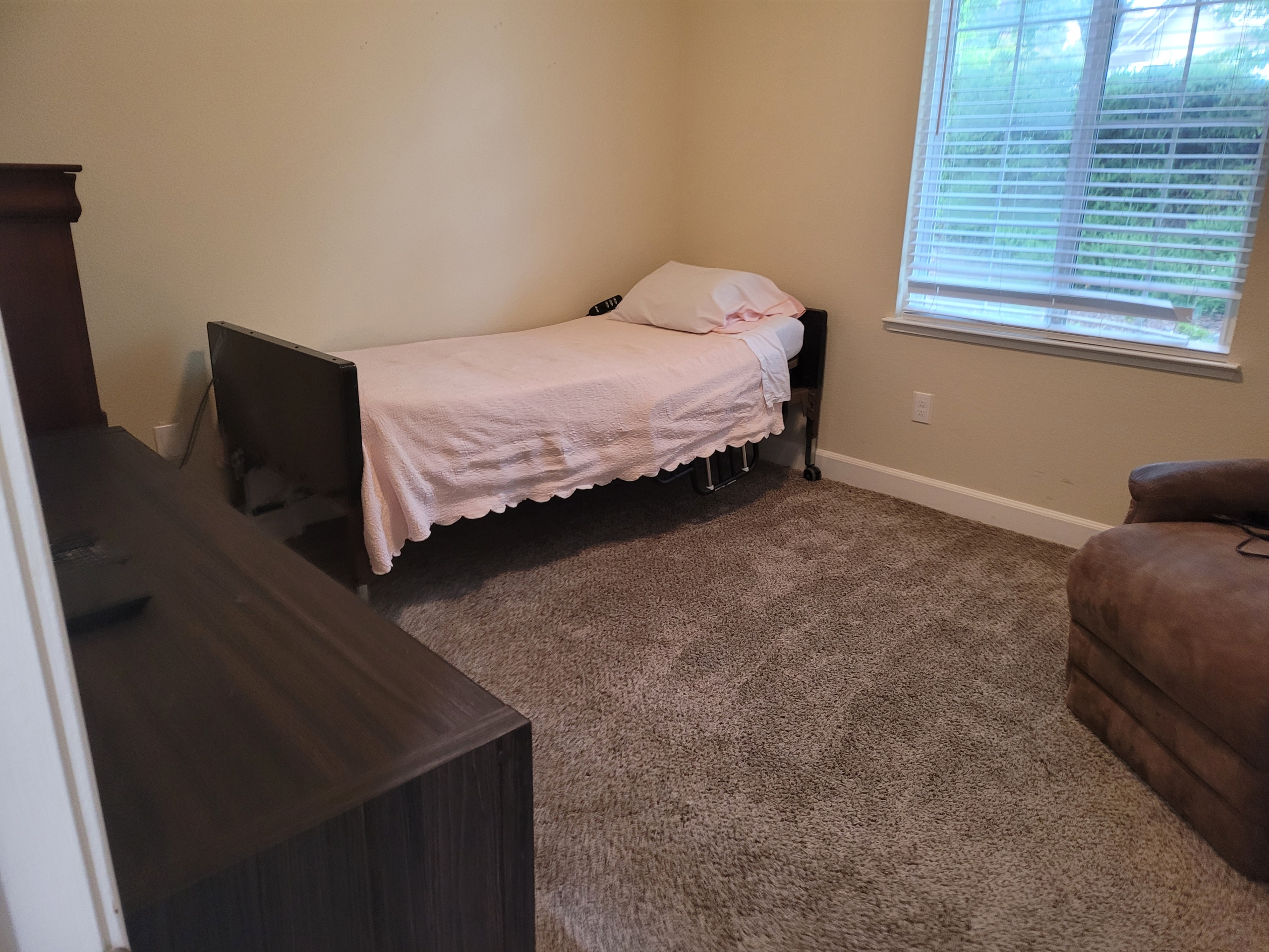 A bed room with a single bed and a desk