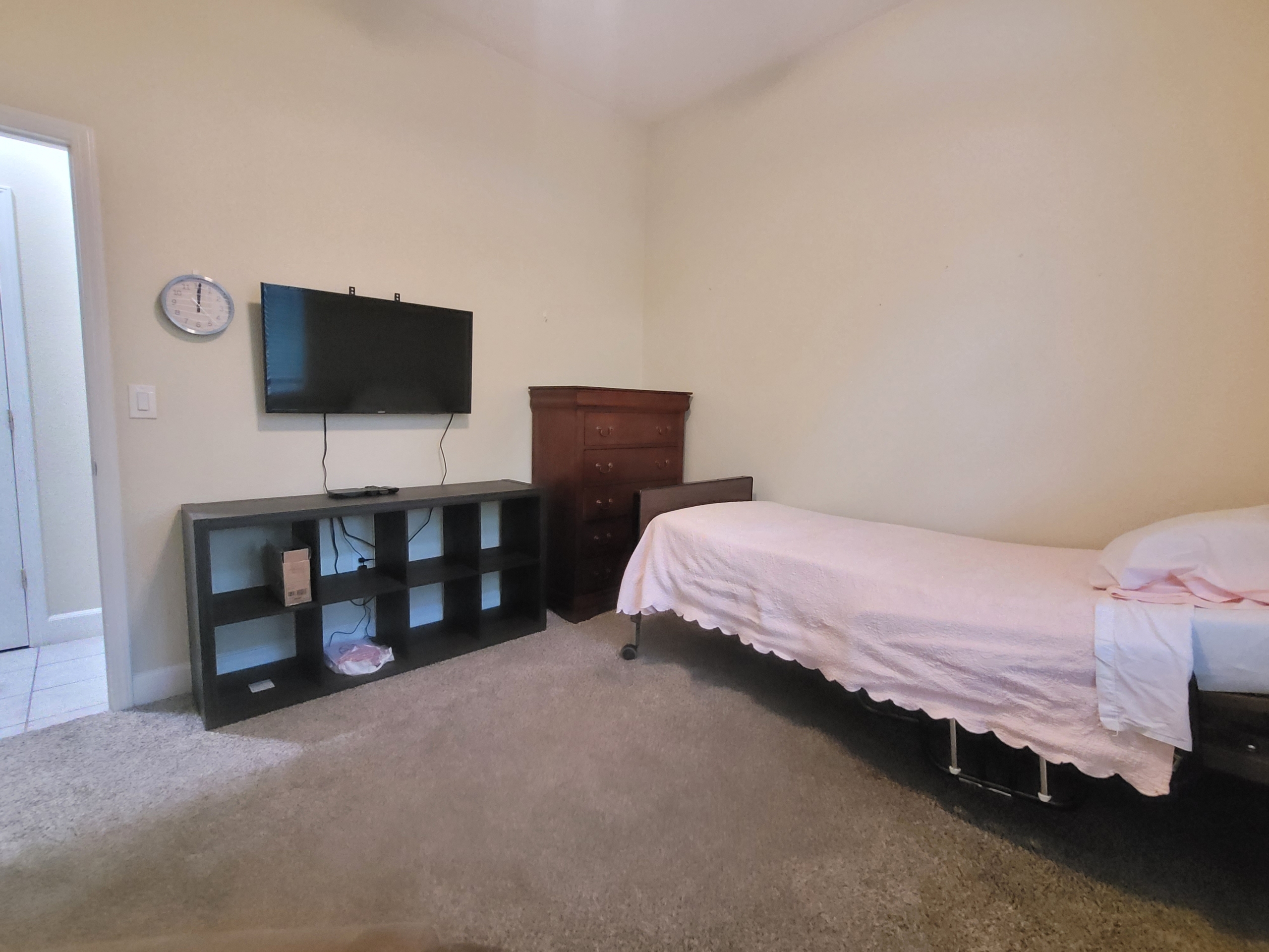 A bed room with a tv and a small cabinet