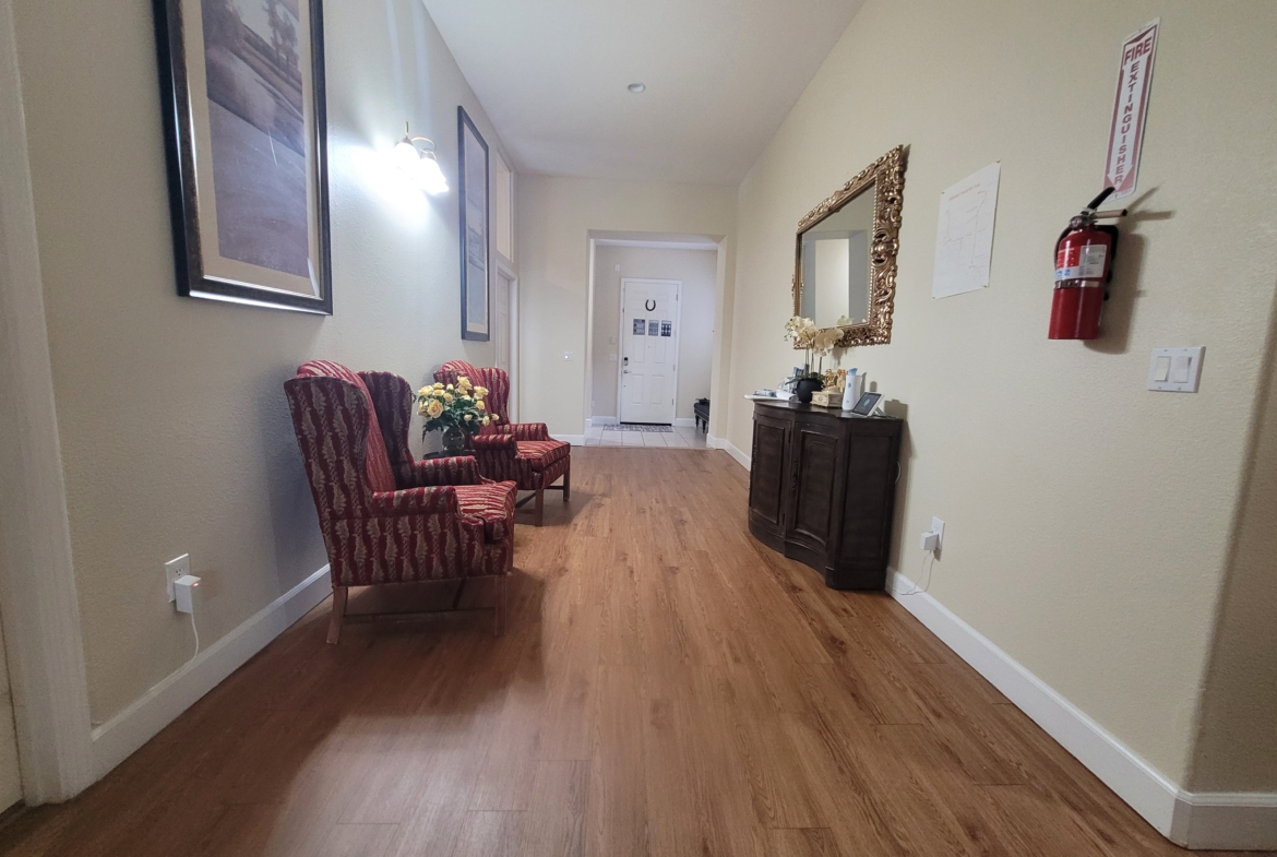 A hallway with two chairs and a mirror.