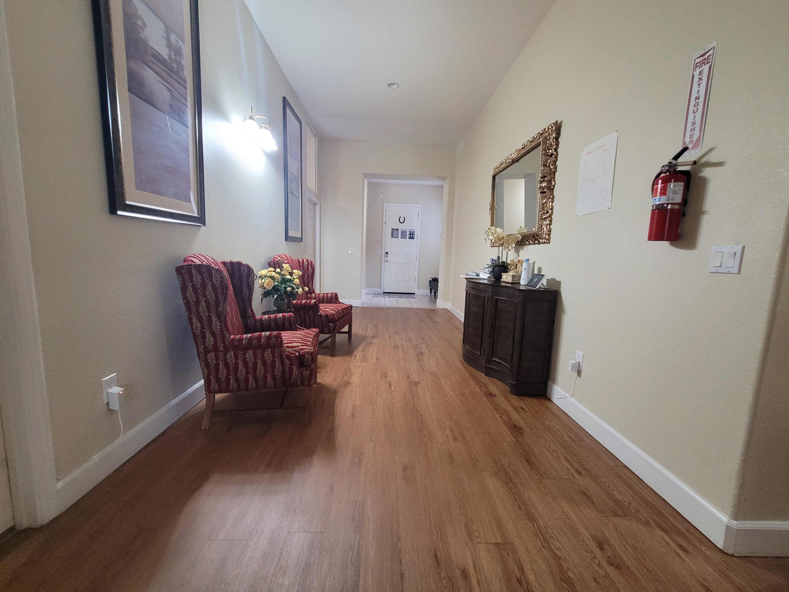 A hallway with two chairs and a mirror.