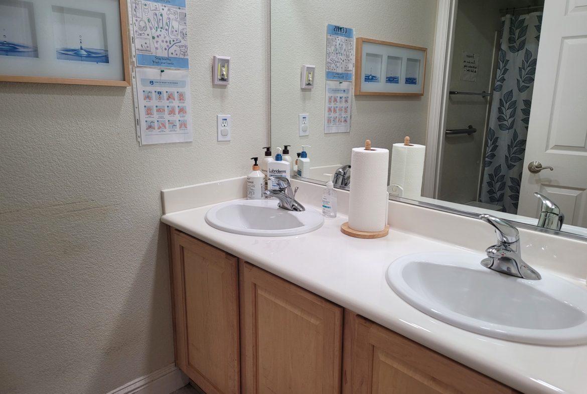 A bathroom with two sinks and a mirror.