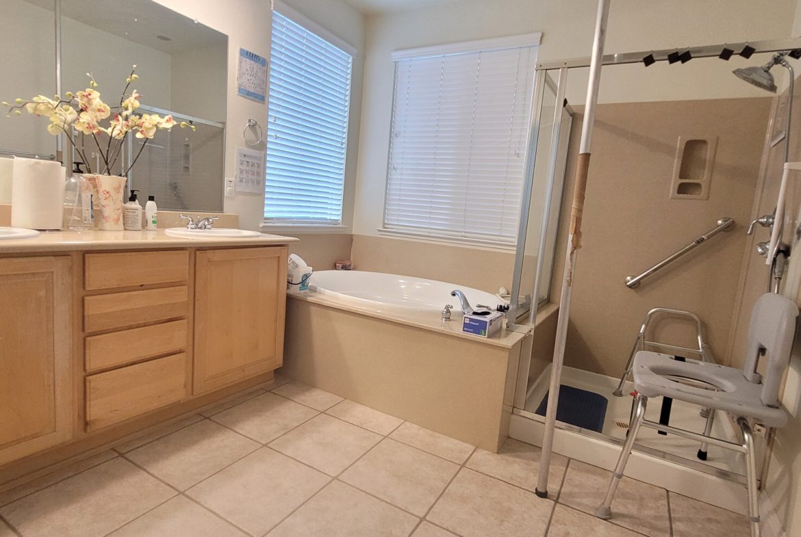 A bathroom with a tub, shower and sink.