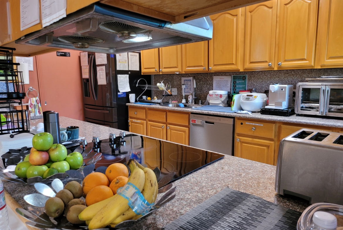 A kitchen with a bowl of fruit on the counter.