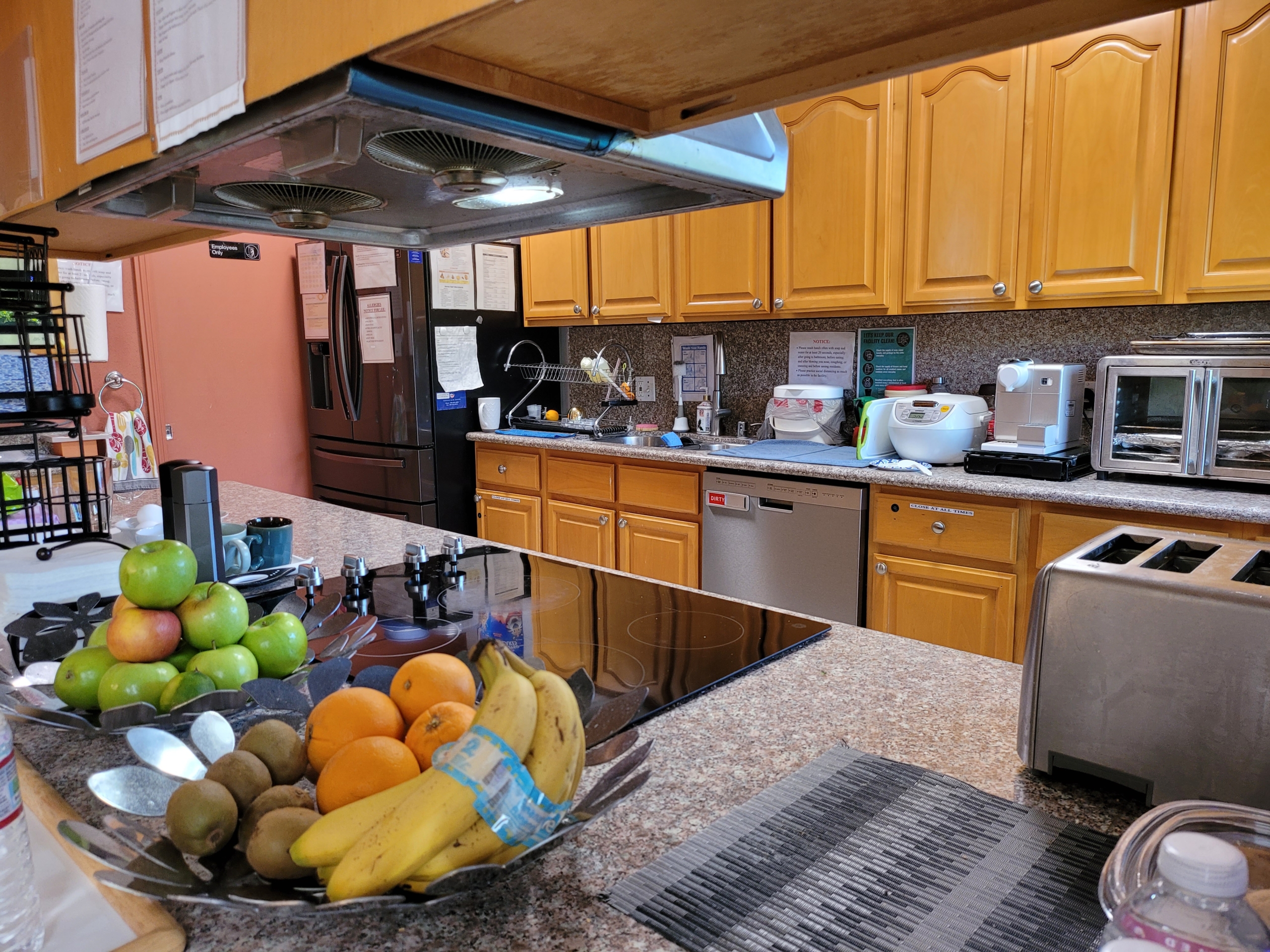 A kitchen with a bowl of fruit on the counter.