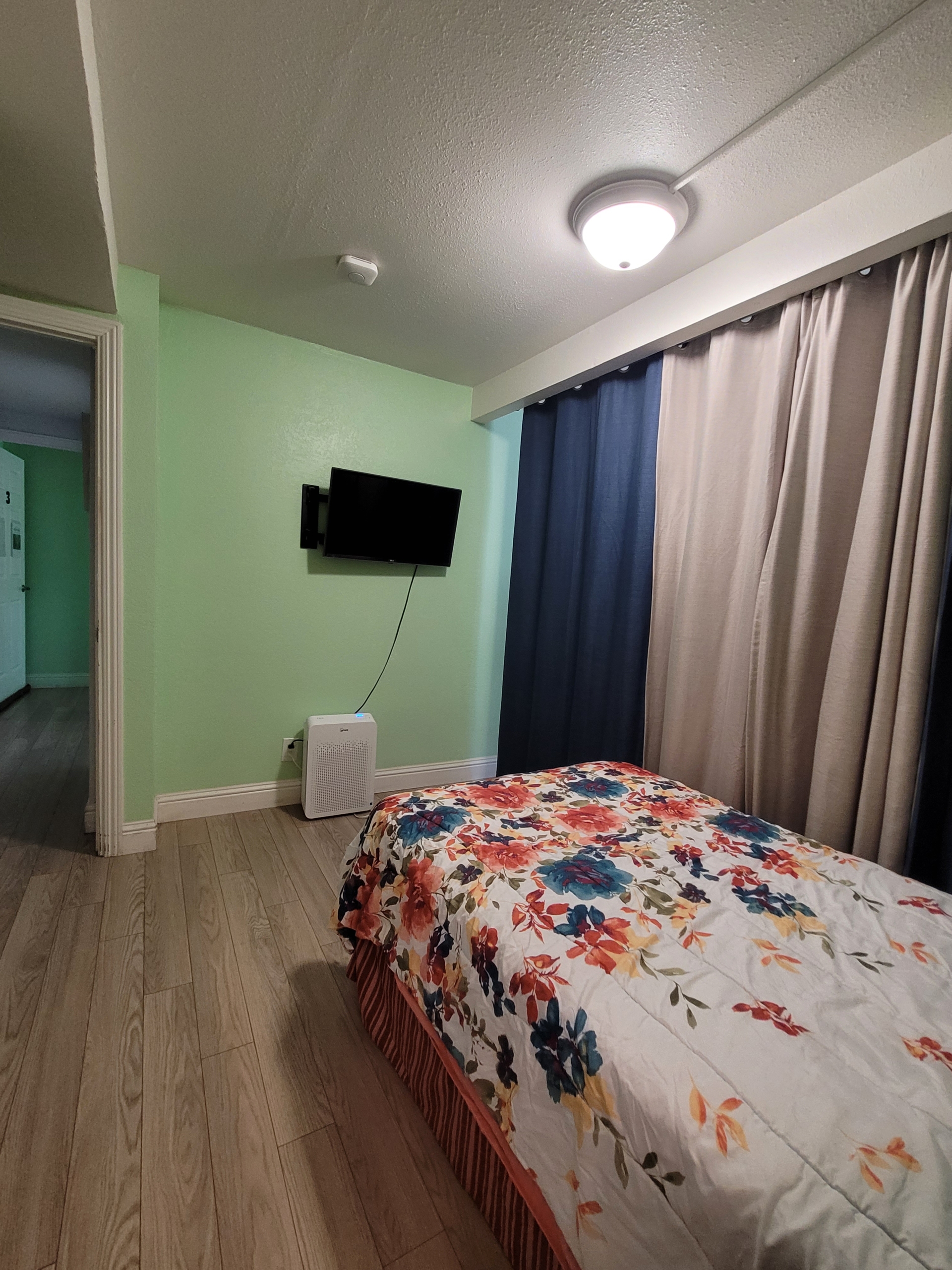 A bedroom with a bed and television in it.