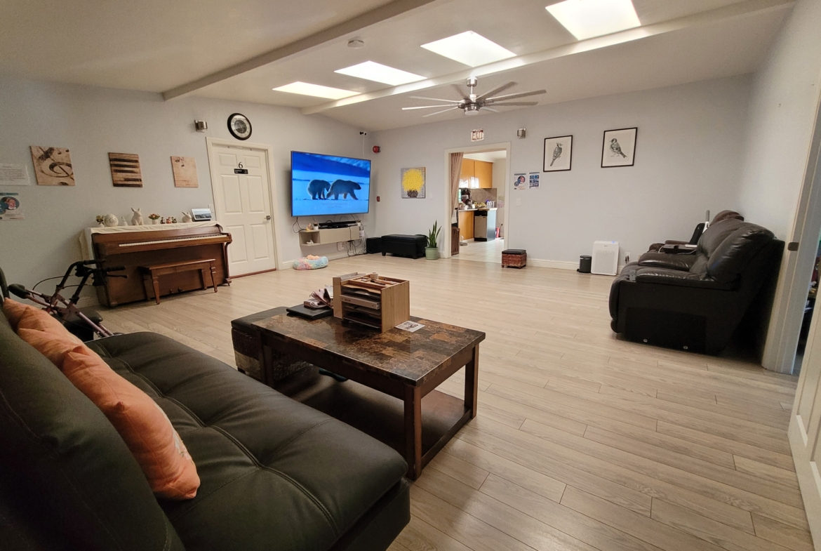 A living room with a couch, table and television.