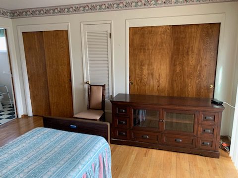 A bedroom with wooden furniture and a blue blanket.