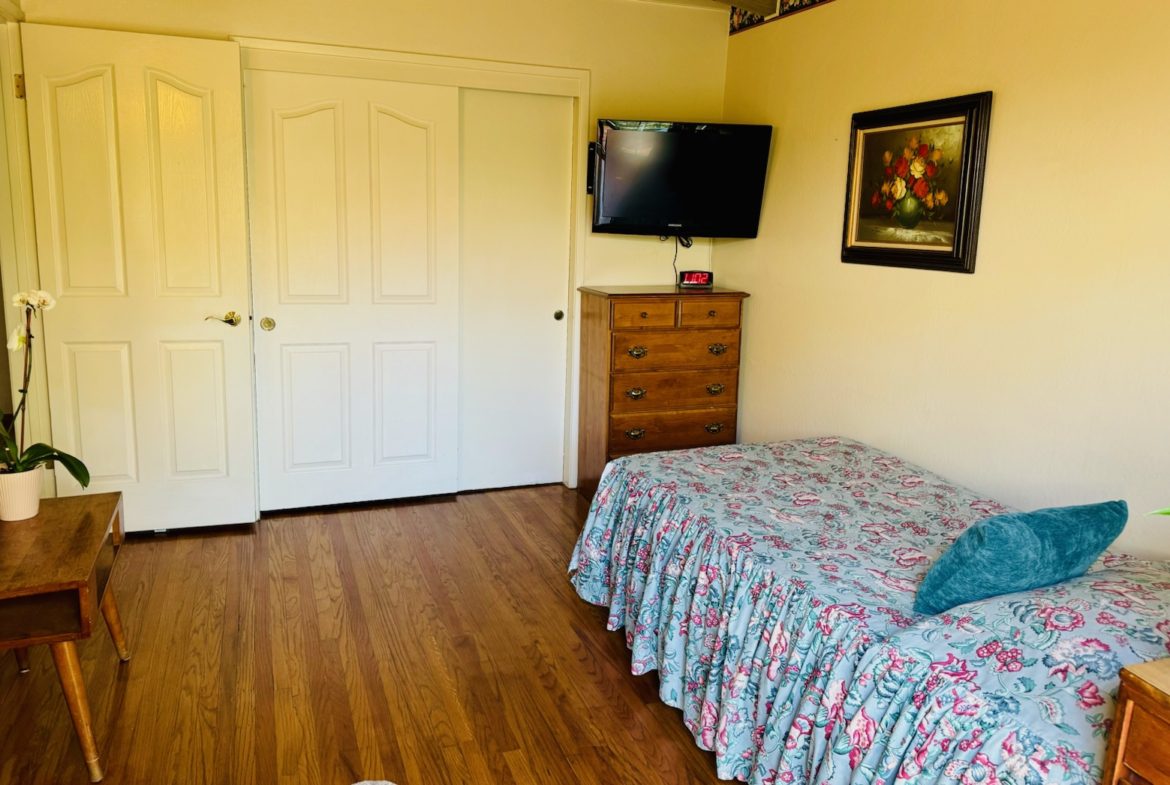 A bedroom with a bed and television in it