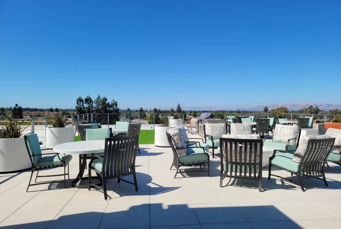 A patio with many chairs and tables on top of it