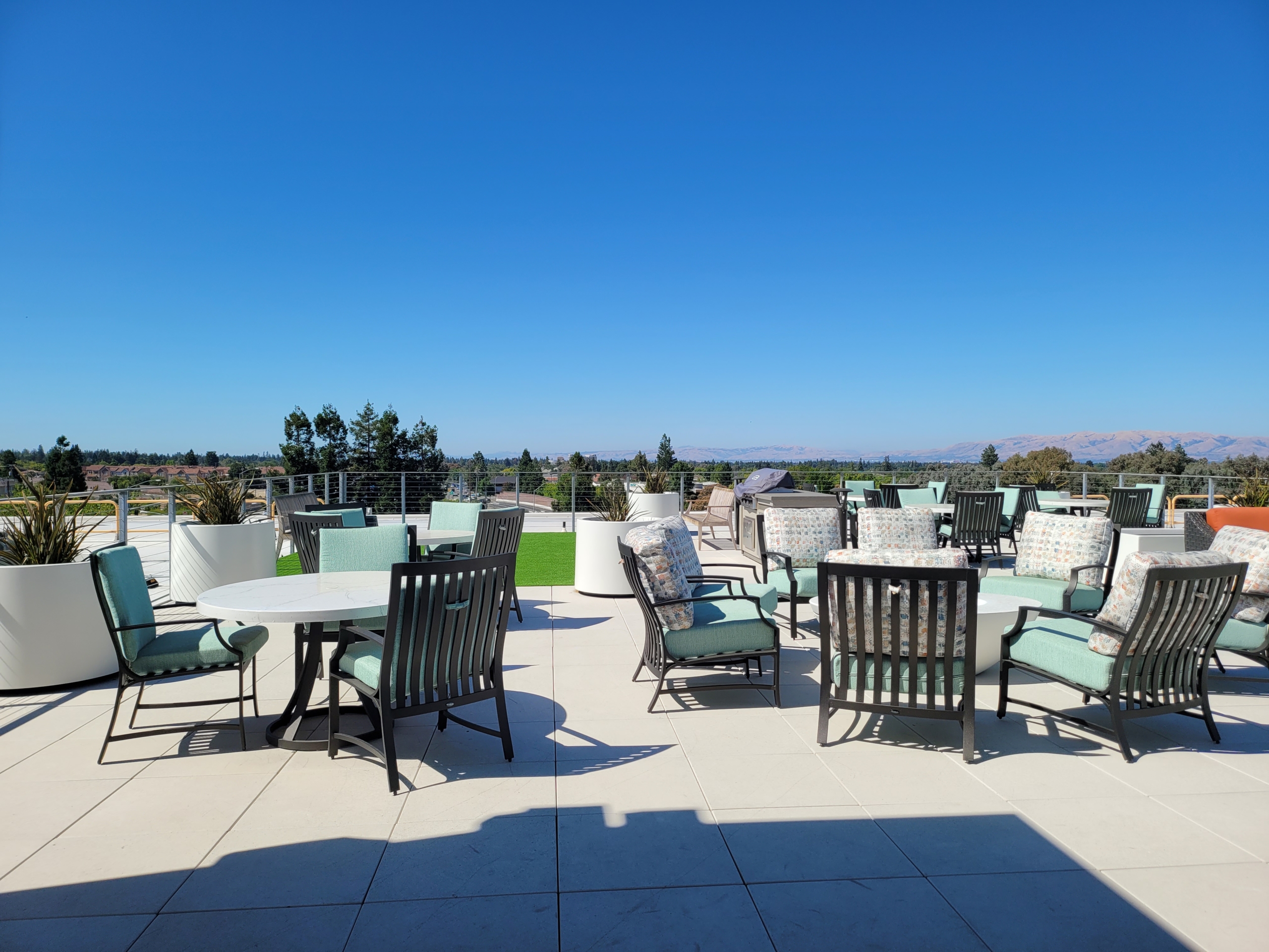 A patio with many chairs and tables on top of it