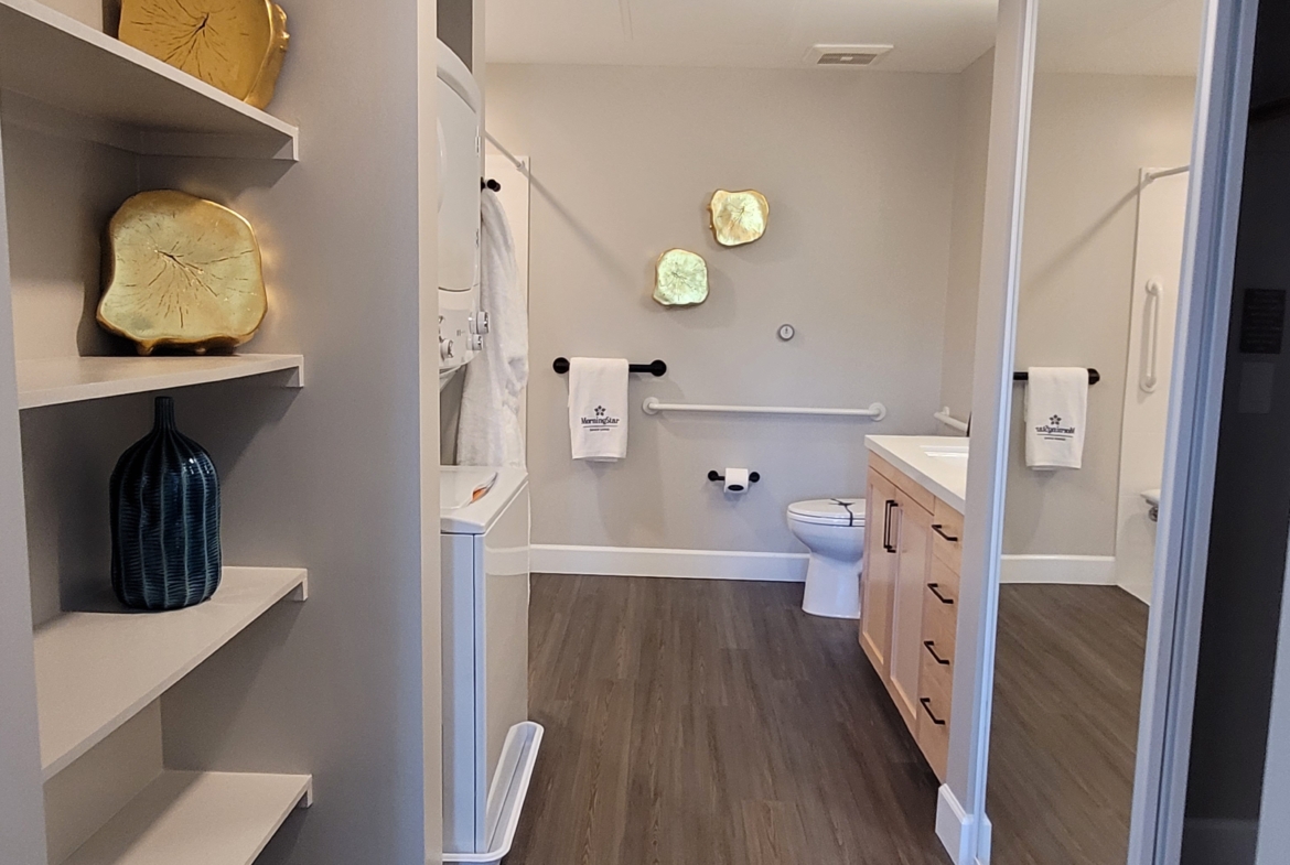 A bathroom with a toilet and shelves in it