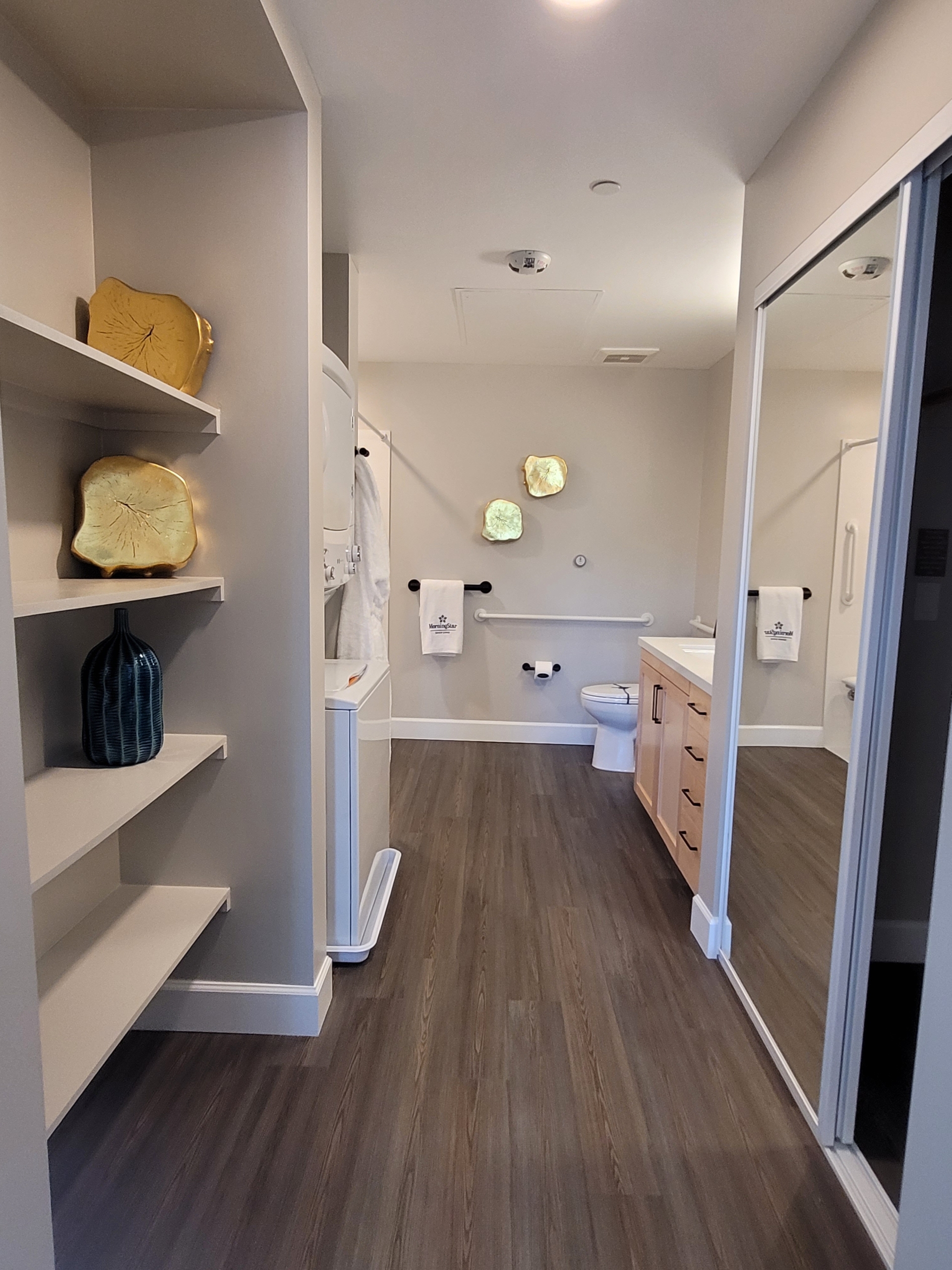 A bathroom with a toilet and shelves in it