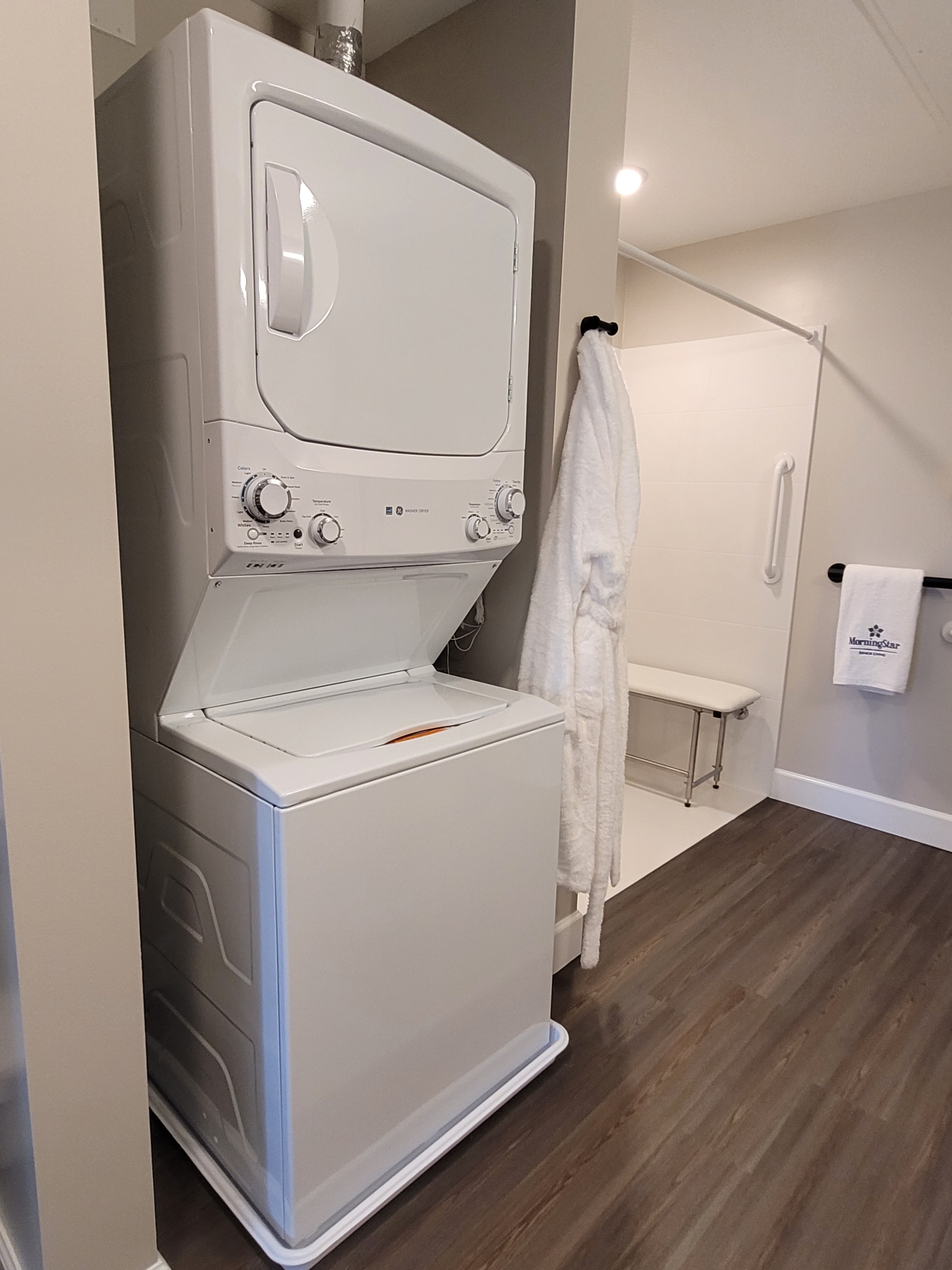 A white washer and dryer in the corner of a room.