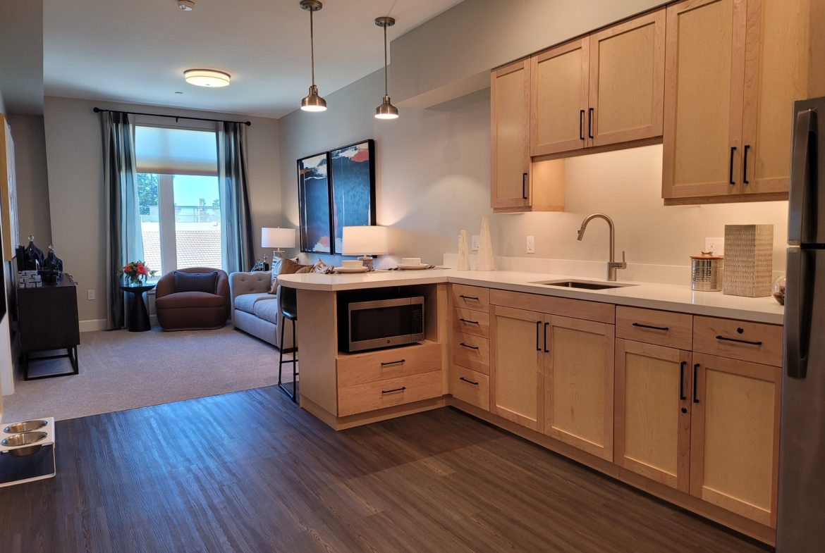 A kitchen with wood floors and cabinets in it