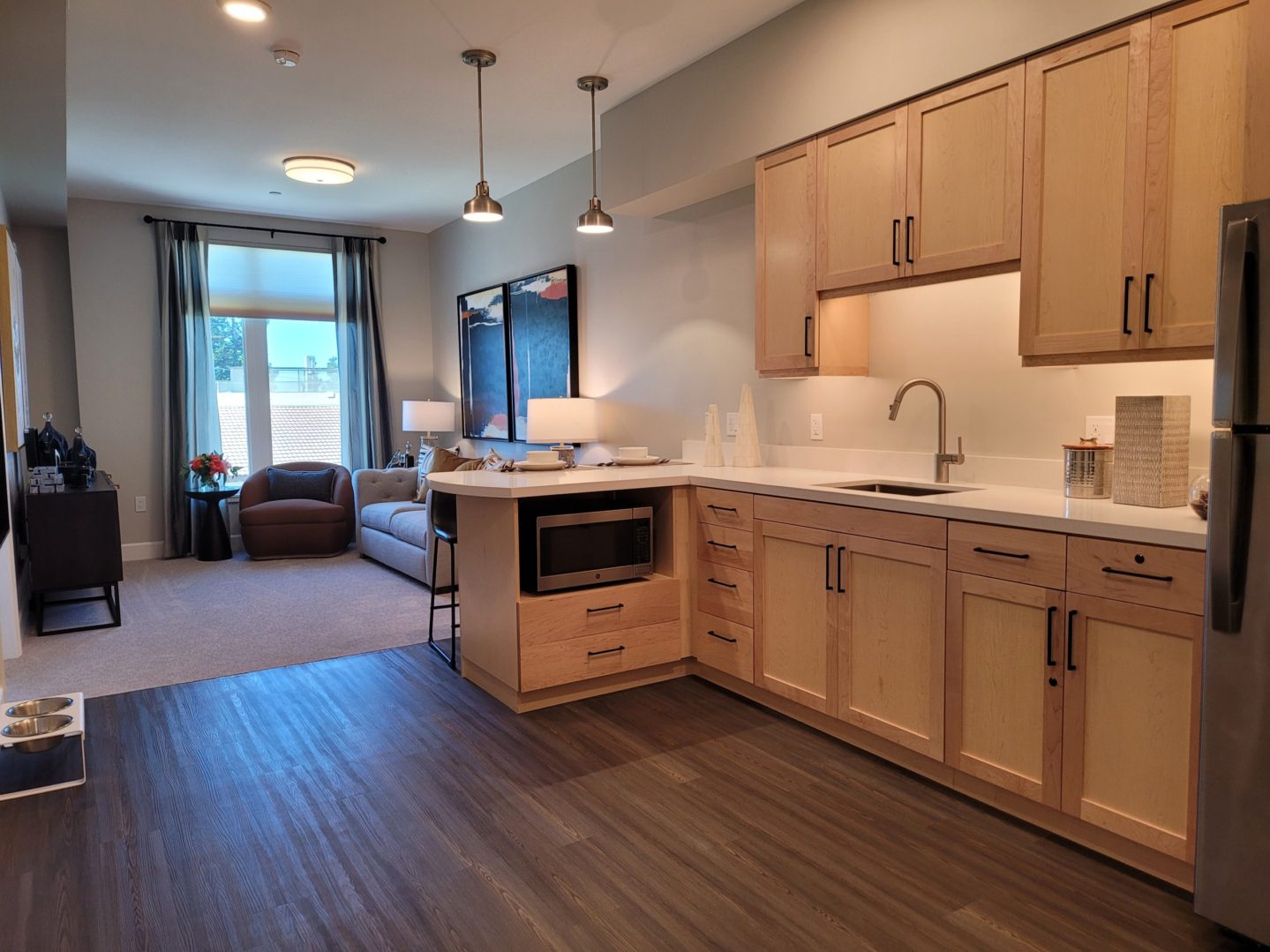 A kitchen with wood floors and cabinets in it