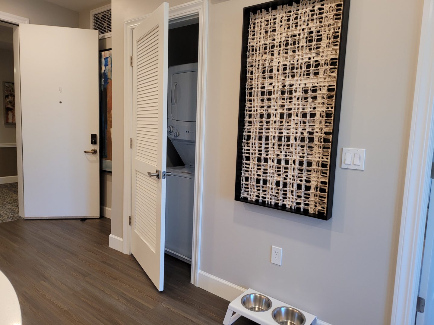 A dog bowl sitting in front of an open door.